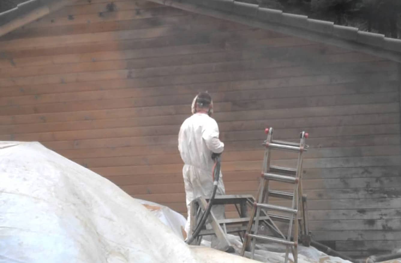 person in PPE using mobile sandless blasting to restore a residential home - Blast From the Past